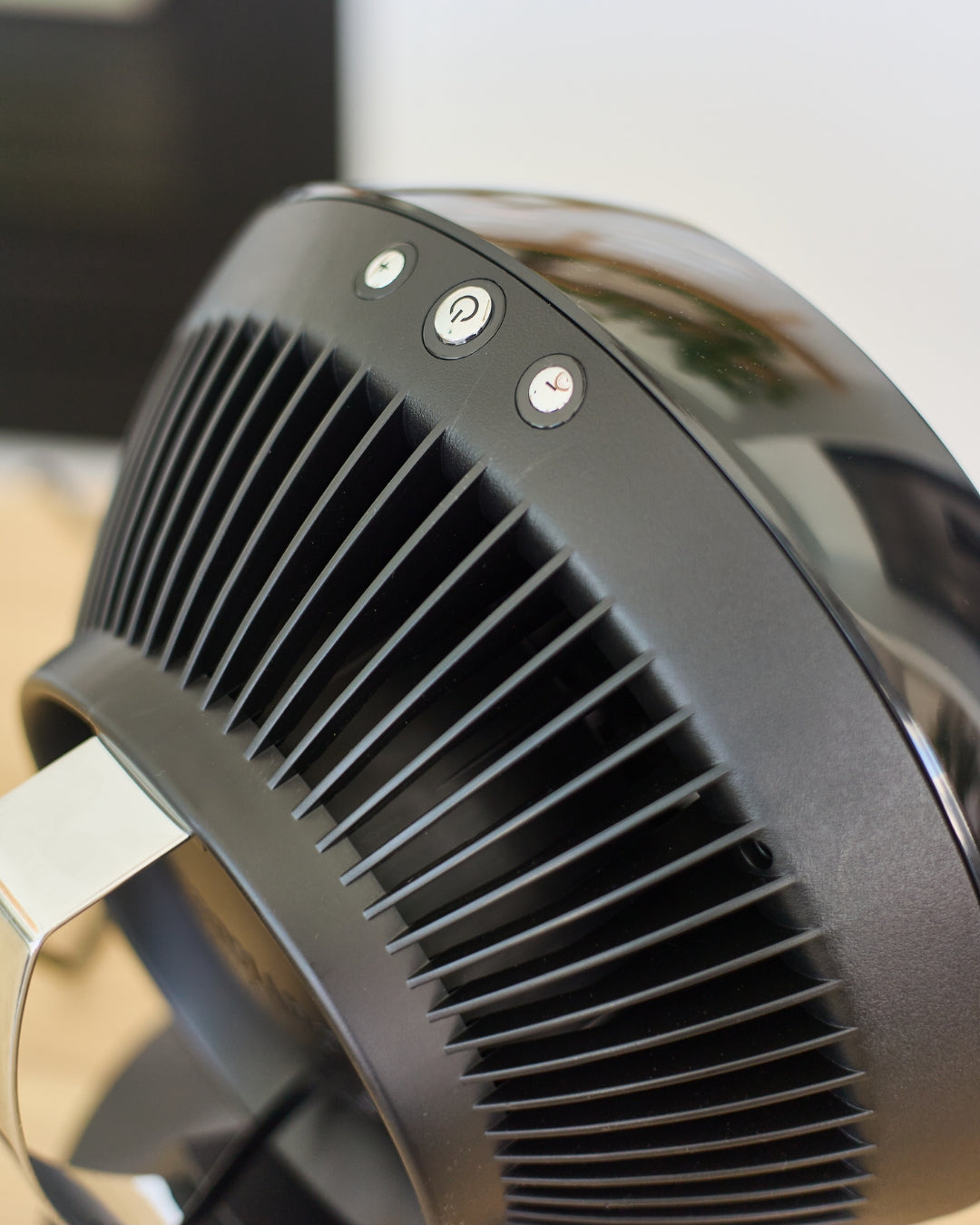 Close-up of a black Vornado 560 Medium Air Circulator with ventilation grill and control buttons.