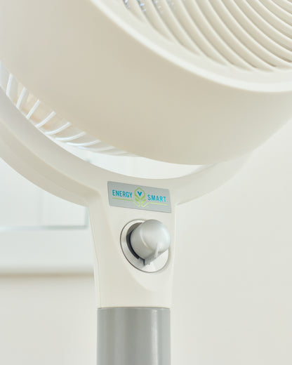 Close-up of a white Vornado 683 Pedestal Air Circulator with a 'Energy Smart' label on a light background